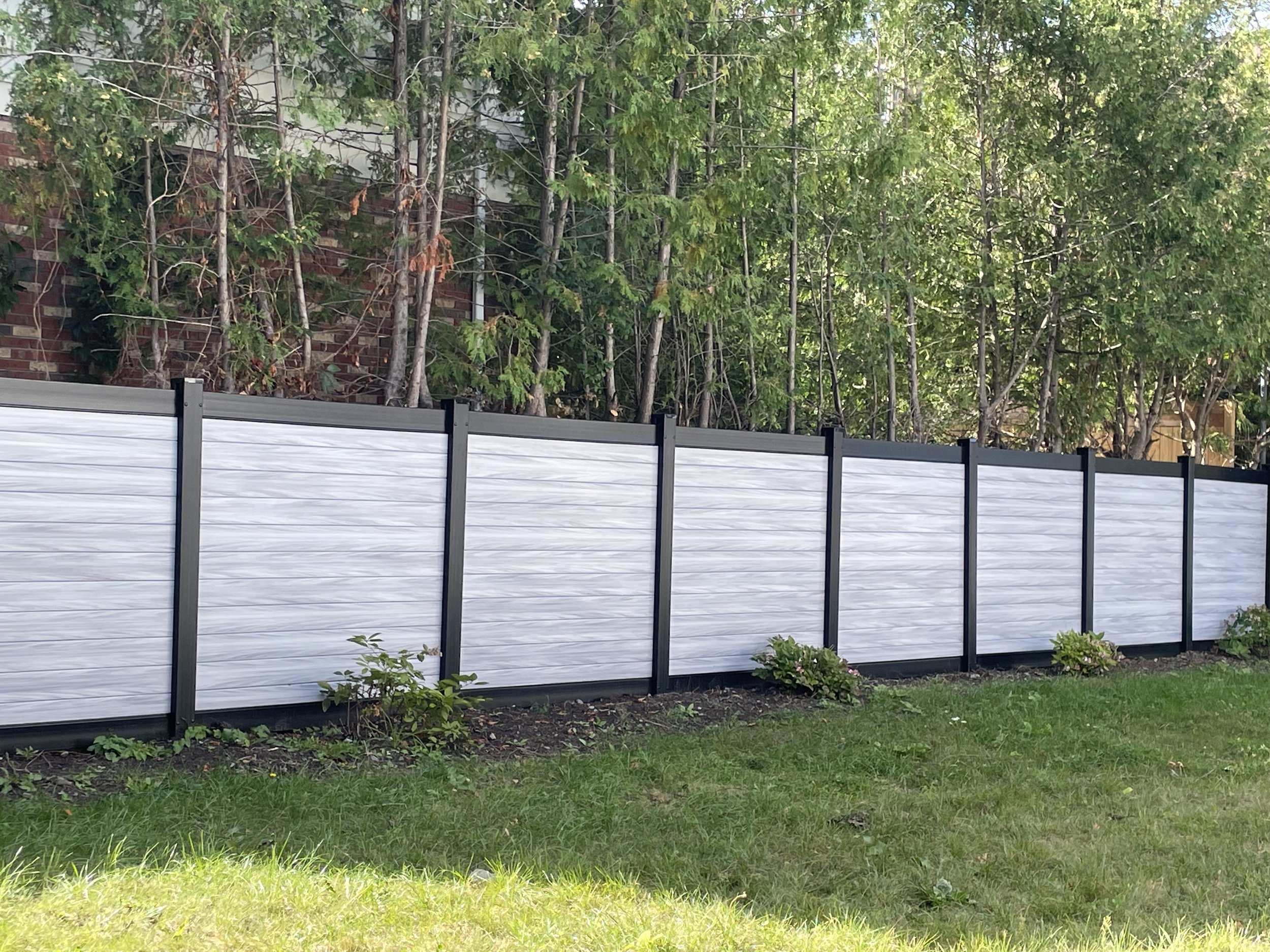 Grey PVC fence with black posts and rails installed by Williamsburg Woods and Garden, Ontario