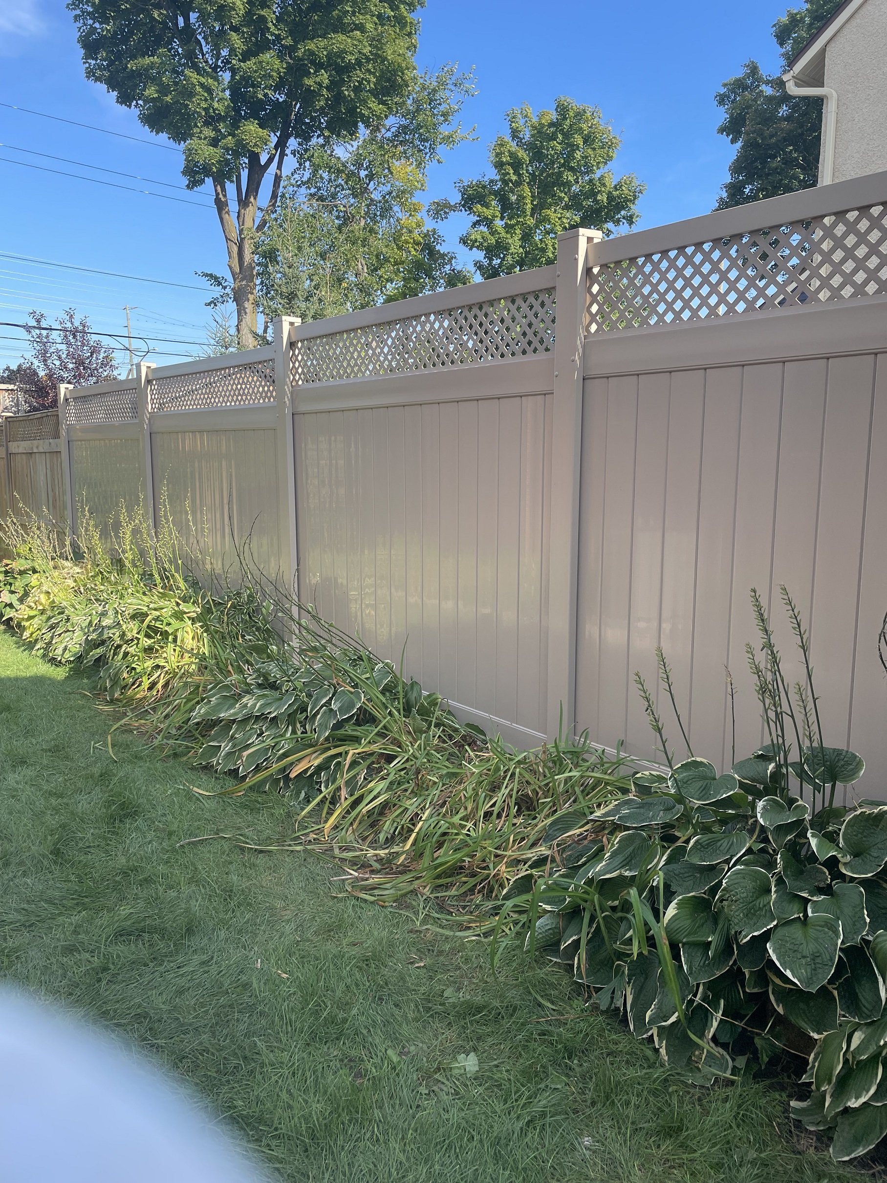 Tan PVC fence installation by Williamsburg Woods and Garden, Eastern Ontario